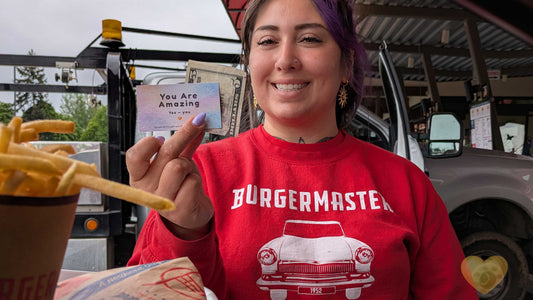 server at burgermaster holding a you are amazing card with tip and smiling