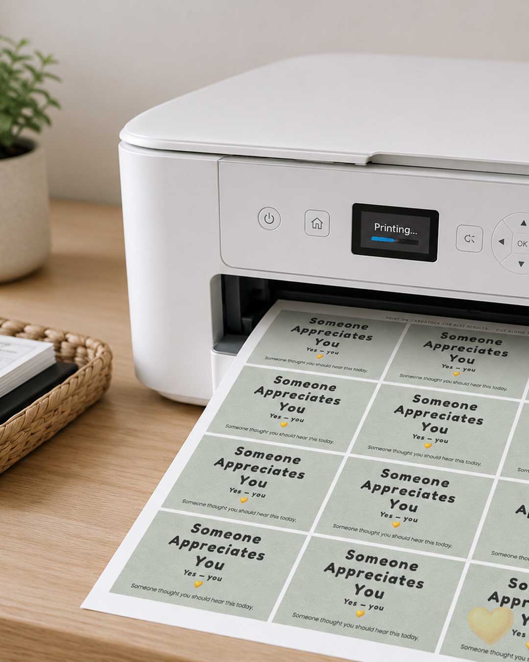 White printer on a wooden table with printed sheets of cards.