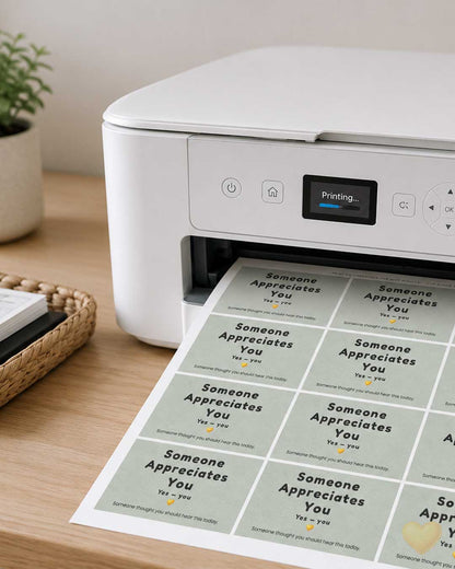 White printer on a wooden table with printed sheets of cards.